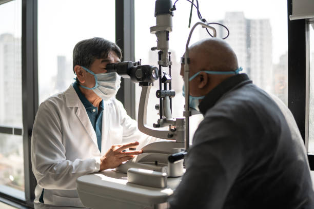 istock Optometrist examining patient's eyes - wearing face mask 1343802193