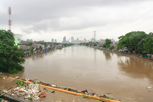 Jakarta, Indonesia - January 17, 2013: The river overflows and is filled with garbage due to heavy rains that hit the city of Jakarta.