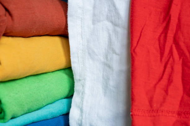 istock A stack of multicolored fabric without inscriptions. Background with folded clothes with blank space for information. T-shirts of different colors 1343813928