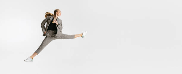 istock Drinking coffee on the go. Female worker isolated over white studio background. Ballet style movement 1343815204