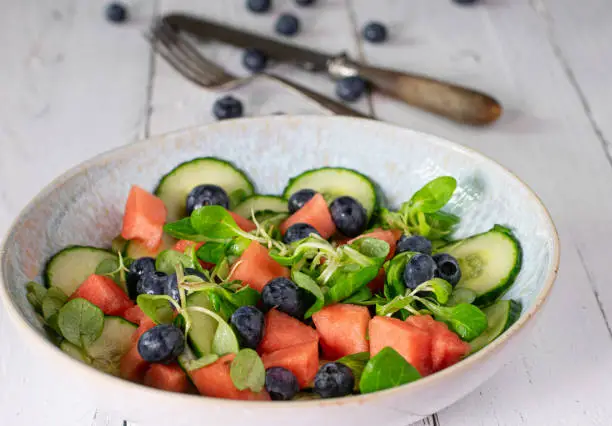 Delicious homemade salad with watermelon, blueberries, cucumber and lamb´s lettuce marinated with apple cider vinegar and olive oil. Healthy appetizer, side dish or snack for soft health