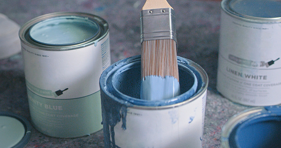 Jars with watercolor paints and a canvas for coloring on a pink background with copy space. Top view. Flat lay.