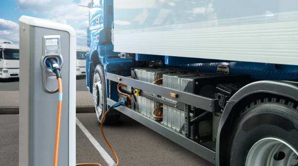 Electric truck with charging station Electric truck batteries are charged from the charging station. Concept commercial land vehicle stock pictures, royalty-free photos & images