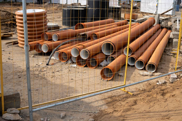 istock Plastic orange pipes lie on the ground at a construction site 1343828575