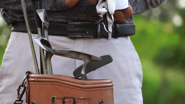 Golfer Putting on golf gloves to compete in golf