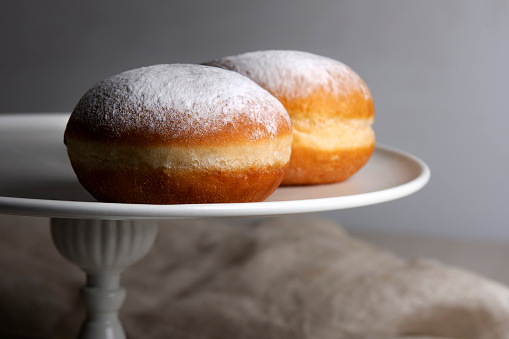 Close up on European donuts with powdered sugar and marmalade filling. A sweet dessert for every occasion usually made for celebration of Mardi Gras.