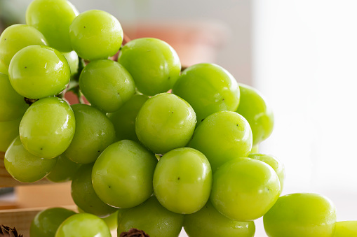 Fresh green grape on the table with light reflection and shadows