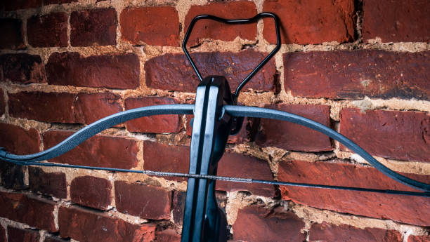 istock A modern compound crossbow handgun on the red brick wall background. Old weapon concept. 1343832209