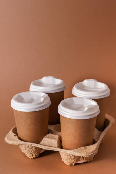 istock Paper cups in a cup holder for takeaway coffee. Paper cup with a drink. Disposable tableware. Eco cardboard recyclable. Brown background. Copy space 1343832922