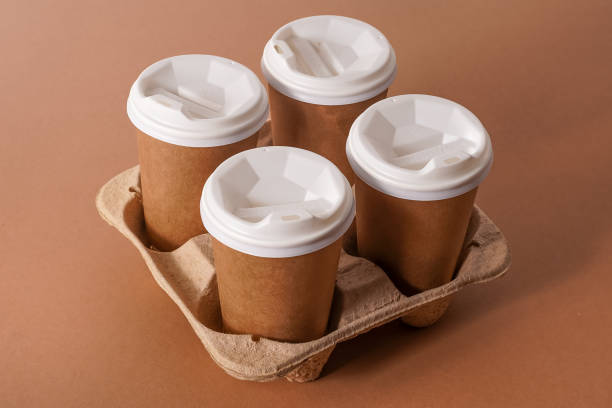 istock Paper cups in a cup holder for takeaway coffee. Paper cup with a drink. Disposable tableware. Eco cardboard recyclable. Brown background. Copy space 1343833445