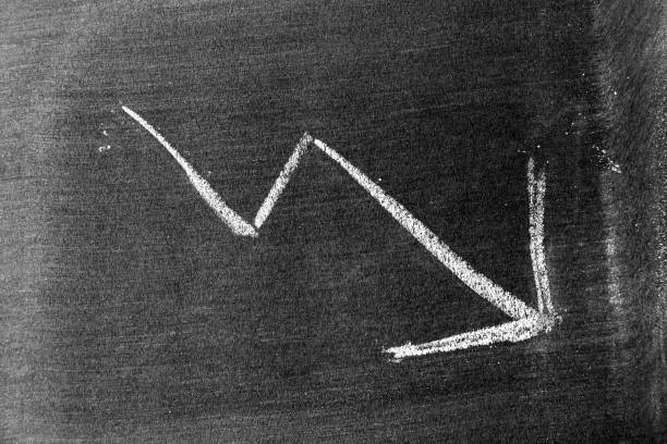 istock White chalk hand drawing in arrow down shape on blackboard or chalkboard background (Concept of stock decline, down trend of business, economy) 1343834925