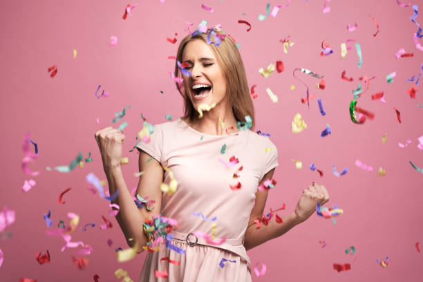 Studio shot of successful young woman celebrating achievement with confetti stock photo