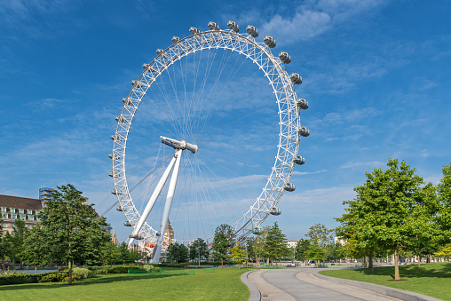 London, England - May 30, 2015:  London Eye and open top double decker bus in the city center in London