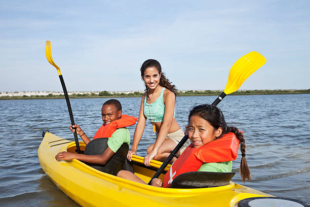 ajudante de colônia de férias com crianças no caiaque - summer camp child teenager kayak - fotografias e filmes do acervo