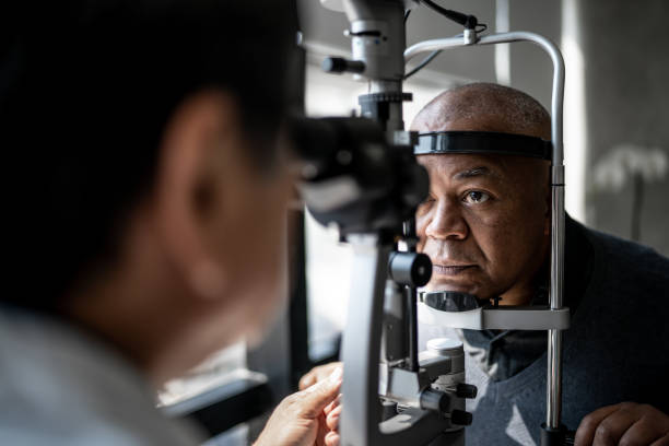 augenarzt, der die augen des patienten untersucht - optometrie stock-fotos und bilder