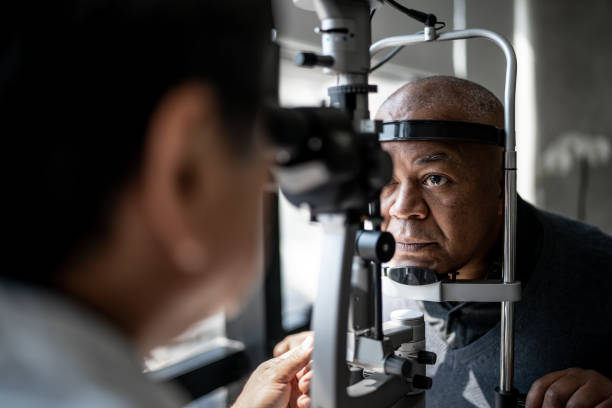 офтальмолог исследует глаза пациента - eye test equipment стоковые фото и изображения