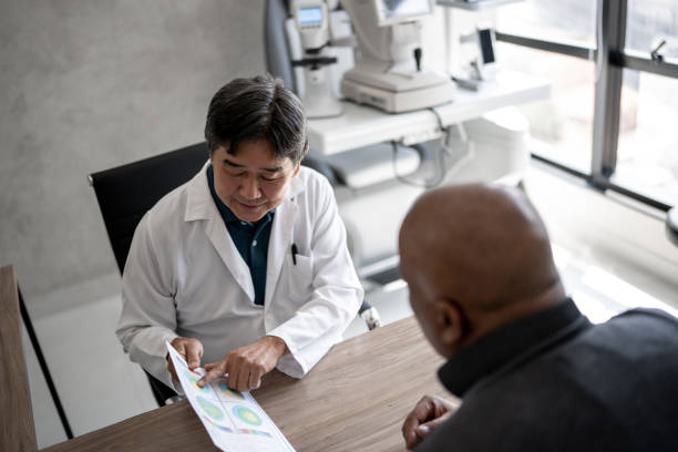 médico hablando con el paciente que muestra exámenes de la vista durante la cita médica - retina display fotografías e imágenes de stock