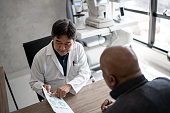 Doctor talking to patient showing eye exams during medical appointment
