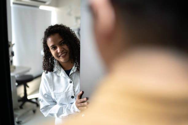 doctor opening door and greeting patient - doctor patient greeting talking imagens e fotografias de stock