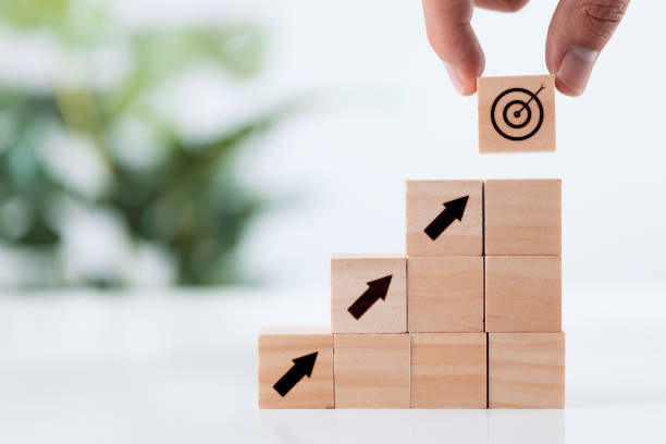 istock Achievement goal and objective target concept, Hand putting virtual target and arrow icon on wooden cube. 1343841020