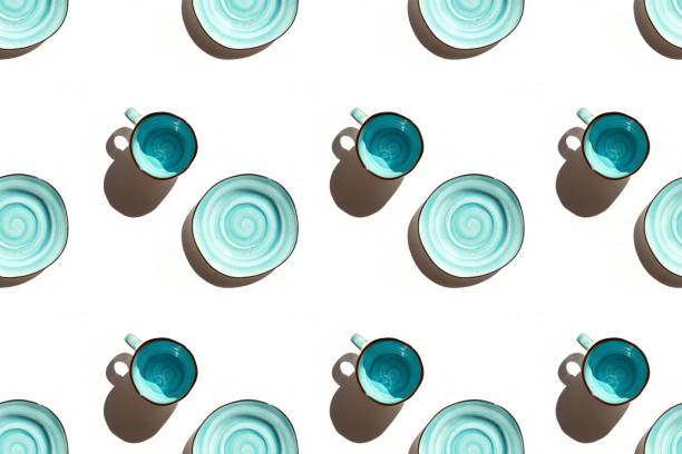 Seamless pattern with aquamarine cup and plate on white textured background. Bright sunshine.