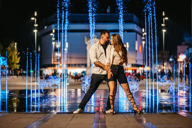 istock Young couple dancing next to colorful fountain 1343846563