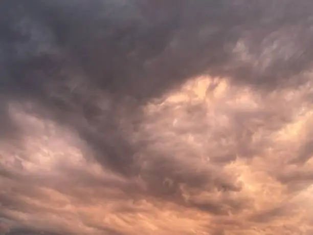 From below thick gray clouds covering sundown sky in dull evening in nature