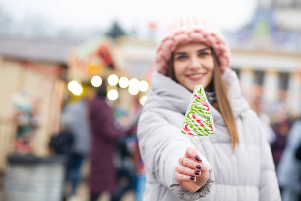 istock Magnificent lady with candy on a christmas fair 1343851180
