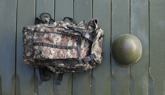 green military backpack on a wooden background