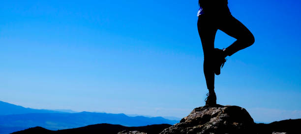 chica en la silueta de la cima de la montaña sosteniendo una postura de yoga para la salud y el bienestar mental - city of sunrise yoga women energy fotografías e imágenes de stock