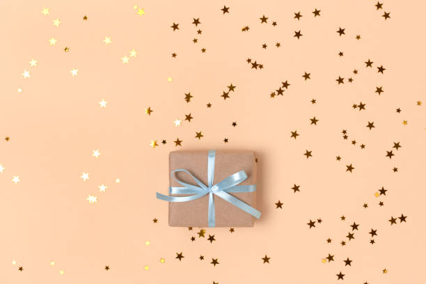 istock Gift box with blue ribbon and gold stars confetti with copy space. 1343851575