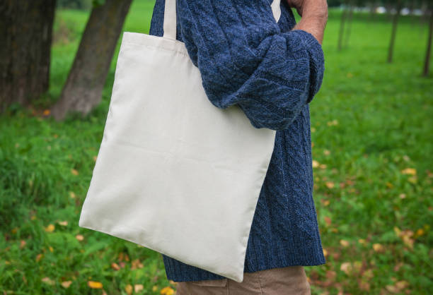istock Stylish man holding white blank canvas tote shopping bag 1343852468