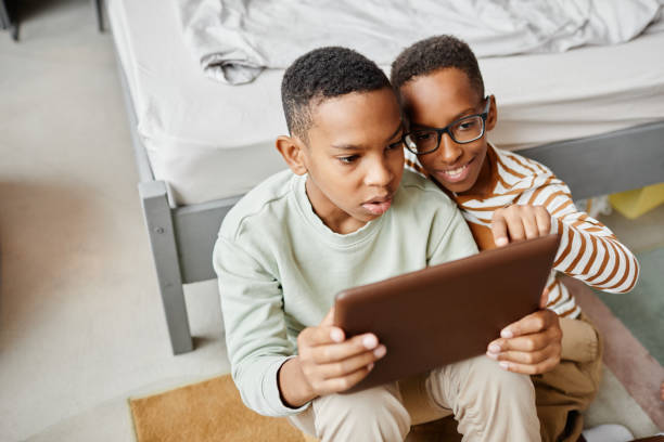 istock African American Boys using Tablet at Home 1343855726