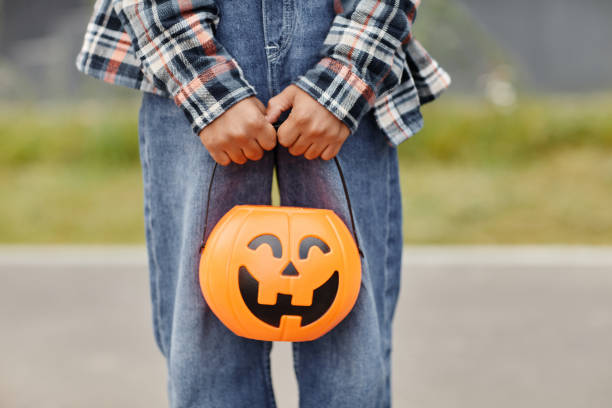 istock Kid Holding Halloween Bucket Close Up 1343855743