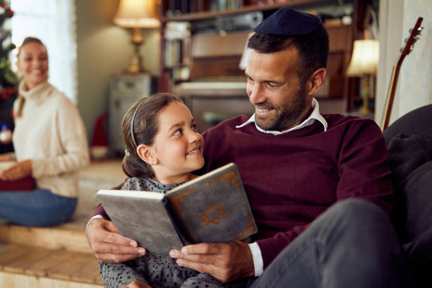 집에서 하누카에서 휴식을 취하면서 타나크를 읽는 행복한 아버지와 딸. - judaism 뉴스 사진 이미지