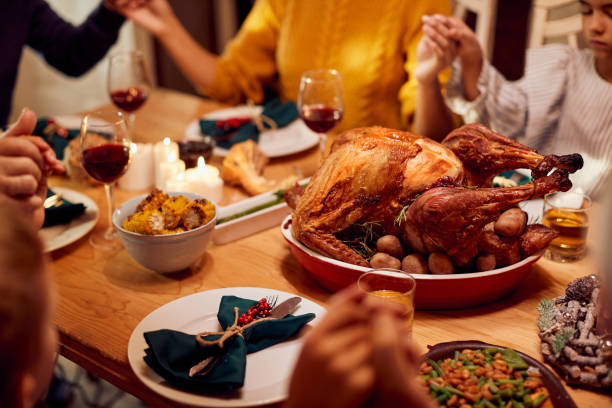 クリスマスランチ中に恵みを言う多世代の家族とロースト七面鳥のクローズアップ。 - praying saying grace dinner meal ストックフォトと画像