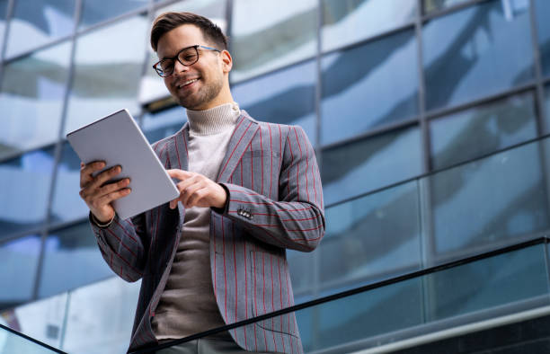 istock Successful happy business man working on digital tablet in urban background 1343865889