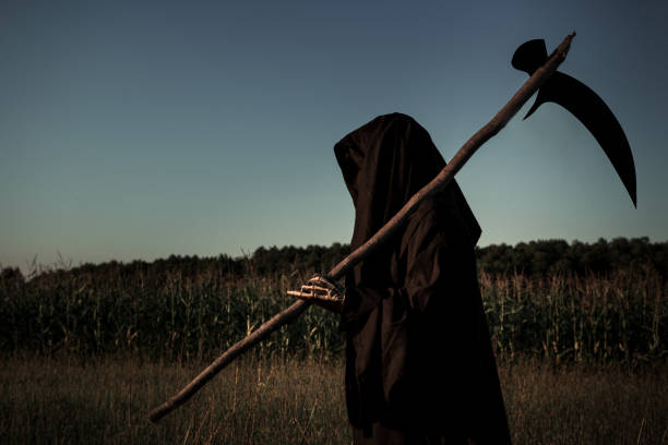 istock Grim Reaper walking in the field holding a scythe. 1343871032