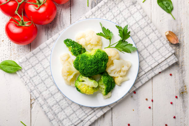 istock steamed broccoli with cauliflower on white plate on white wooden table 1343871231