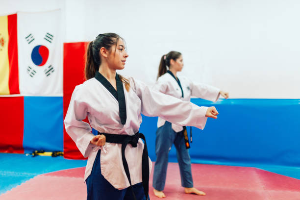 istock Two young women practice taekwondo in a training center 1343872432