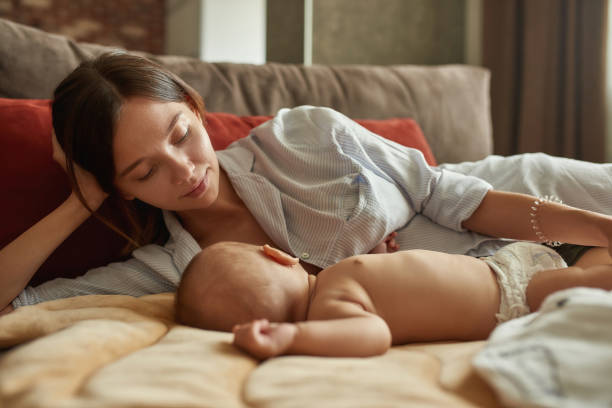 Beautiful mother looking at her baby while breastfeeding
