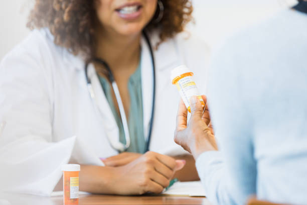 ピルボトルを保持している写真認識できない患者をクローズアップ - pill bottle pill stethoscope medical exam ストックフォトと画像