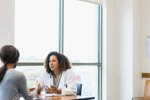 istock Female doctor gestures while discussing medication with unrecognizable patient 1343874703