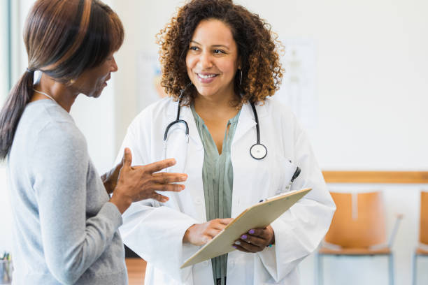 istock Doctor smiles as patient asks questions about information on clipboard 1343874706
