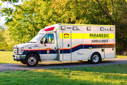 Ottawa, Canada - September 19, 2021: Ambulance parked in park, paramedic on call in public place.