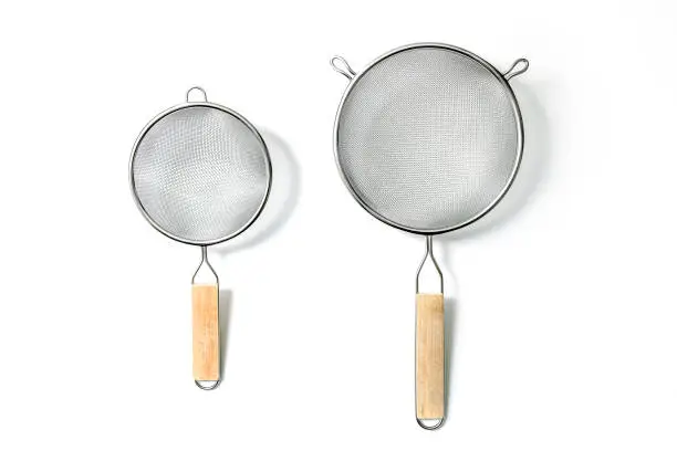 Two Fine Mesh Strainers - large and small. Silver colored metalic colanders with wooden handle isolated on a white background
