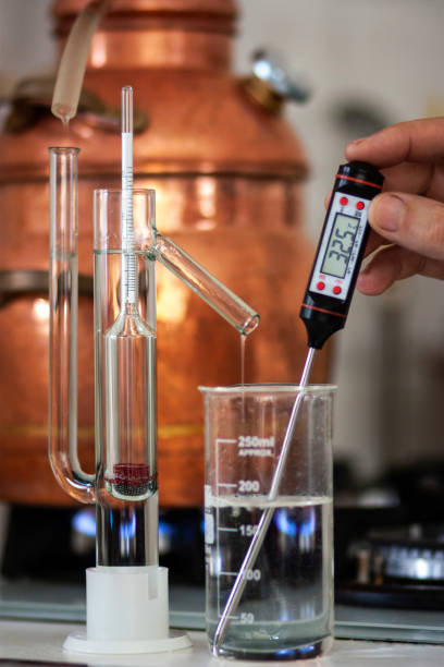 The process of making a strong alcoholic beverage at home. Copper alembic. stock photo