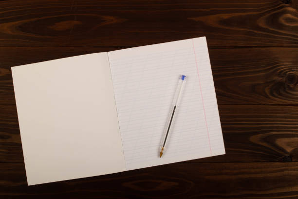 School notebook with lines and pen on the table. School supplies. Copy space School notebook with oblique lines, transparent pen on the table brown wooden background. Blank sheet of paper in notebook on the desk. Back to school. School supplies. Top view. Copy space for text workbook paper checked mesh stock pictures, royalty-free photos & images