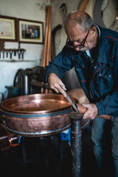 istock An old man,a worker in a workshop for making cauldrons for an alcohol distillation. 1343879597
