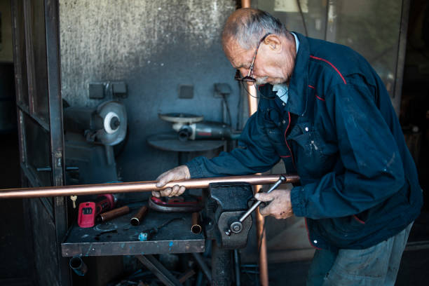 istock An old man,a worker in a workshop for making cauldrons for an alcohol distillation. 1343879612